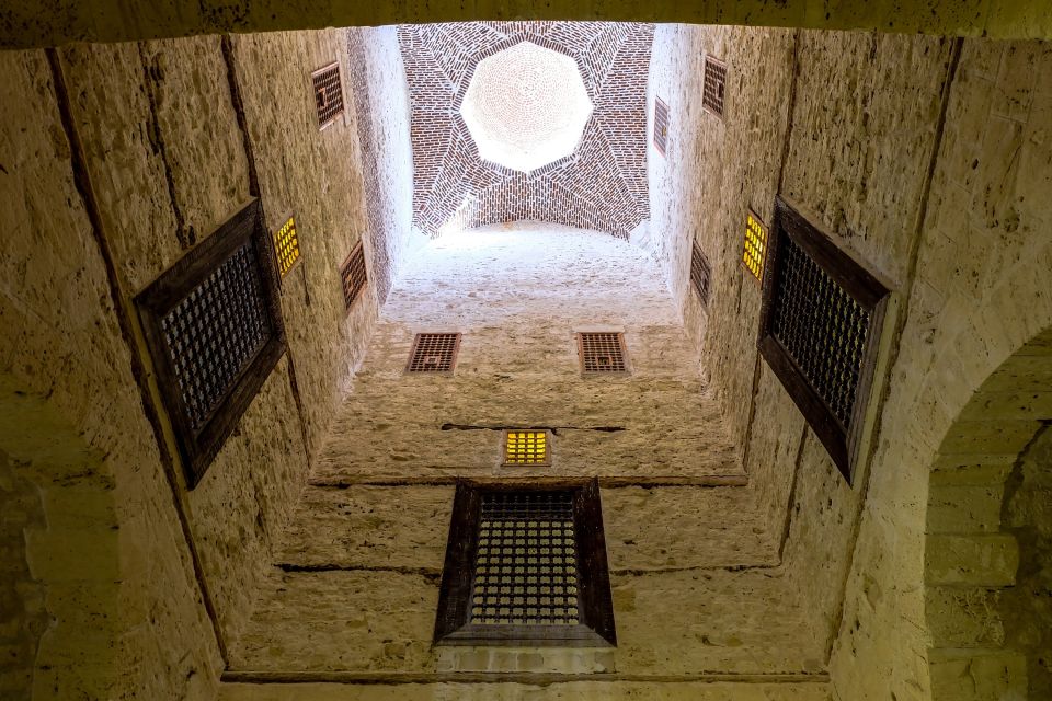 Interior view of a historical dome ceiling with geometric patterns and windows.