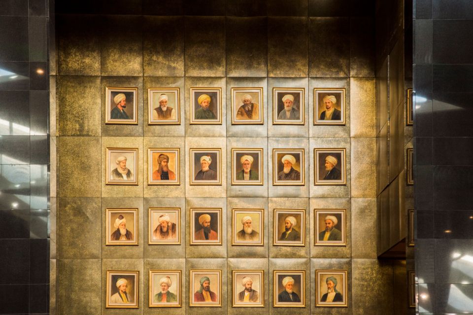 A wall display of framed portraits in golden frames, illuminated by ambient lighting.